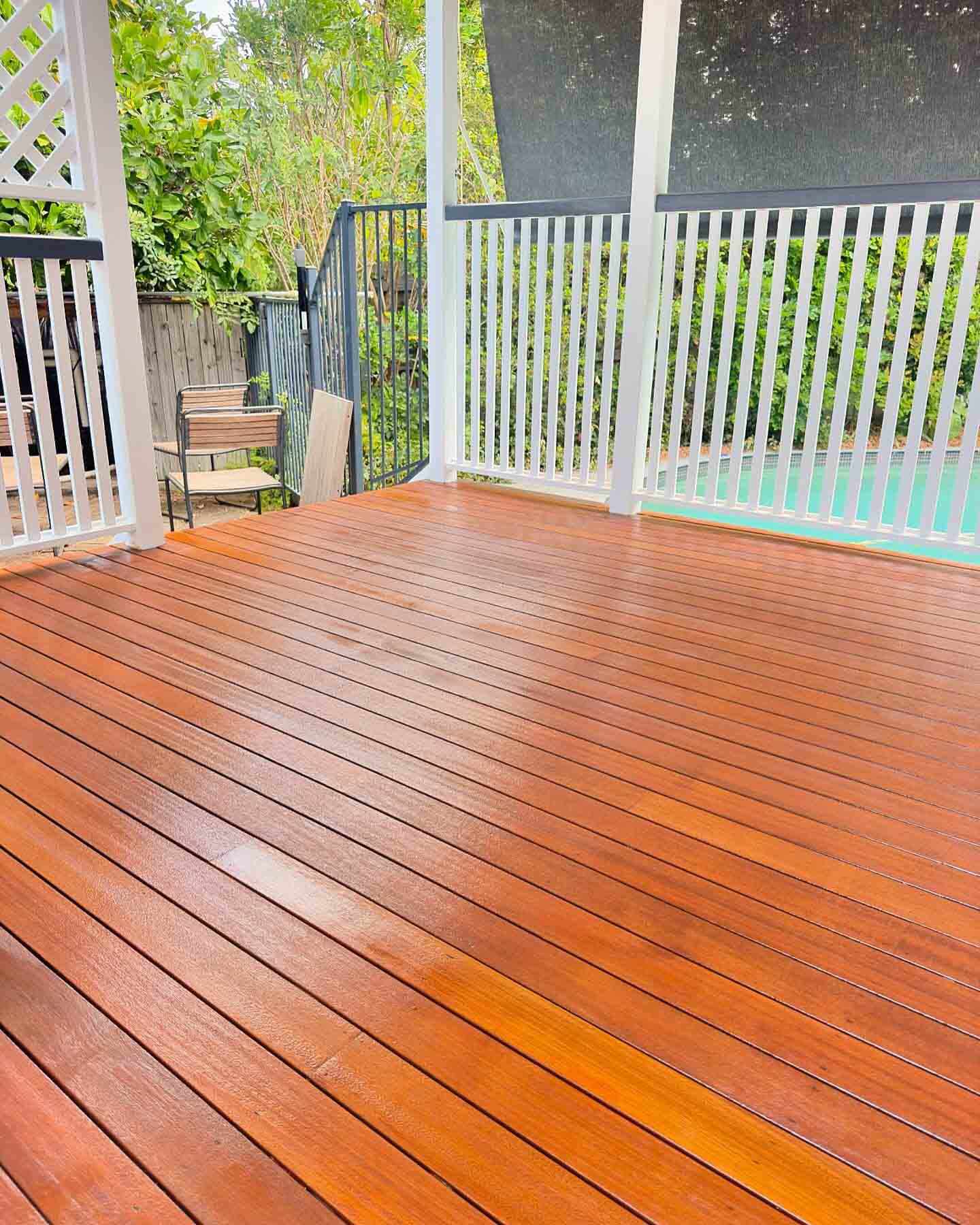 Oiled timber deck with white timber balustrade overlooking a pool
