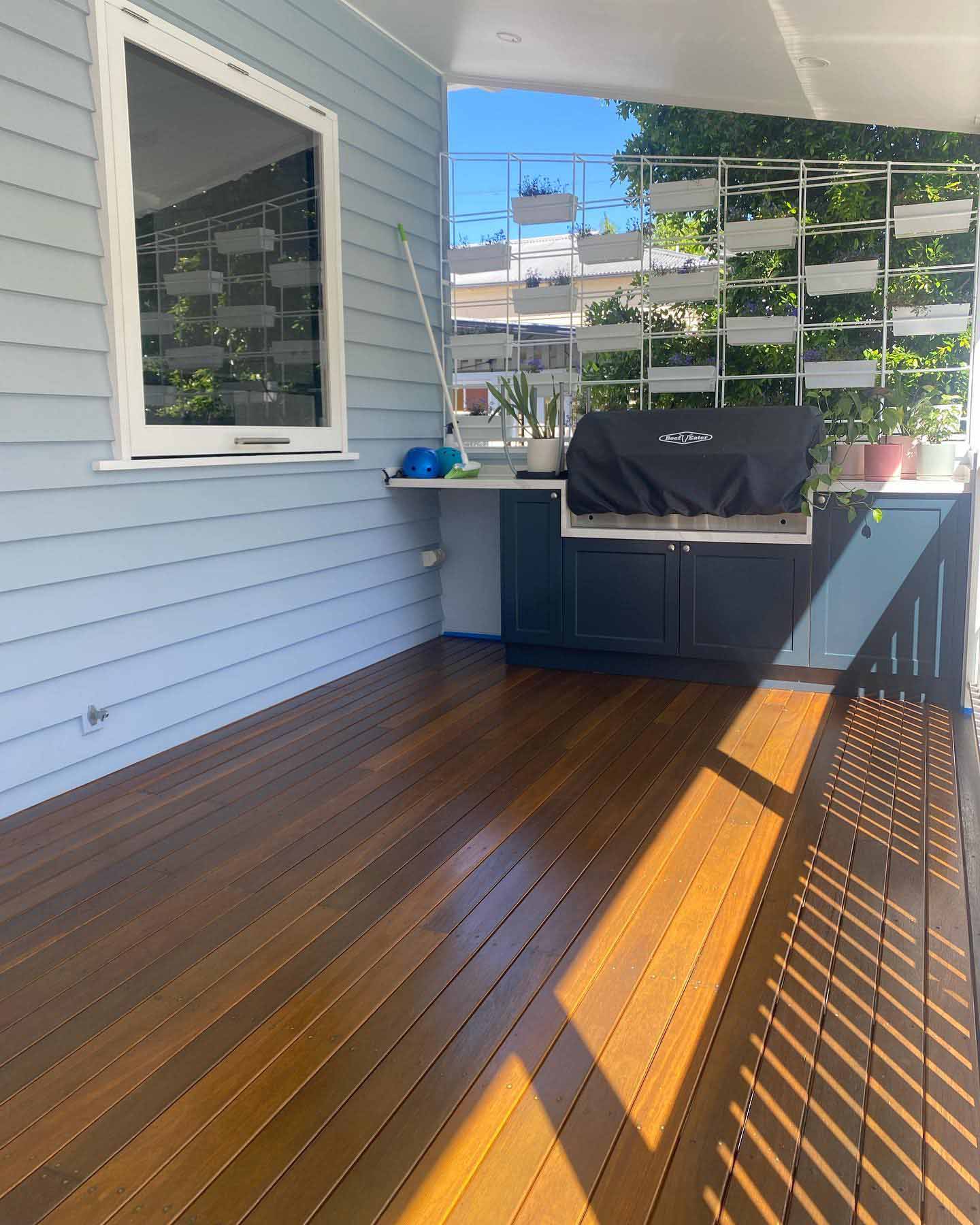 Oiled timber deck under a patio with an outdoor barbecue kitchen