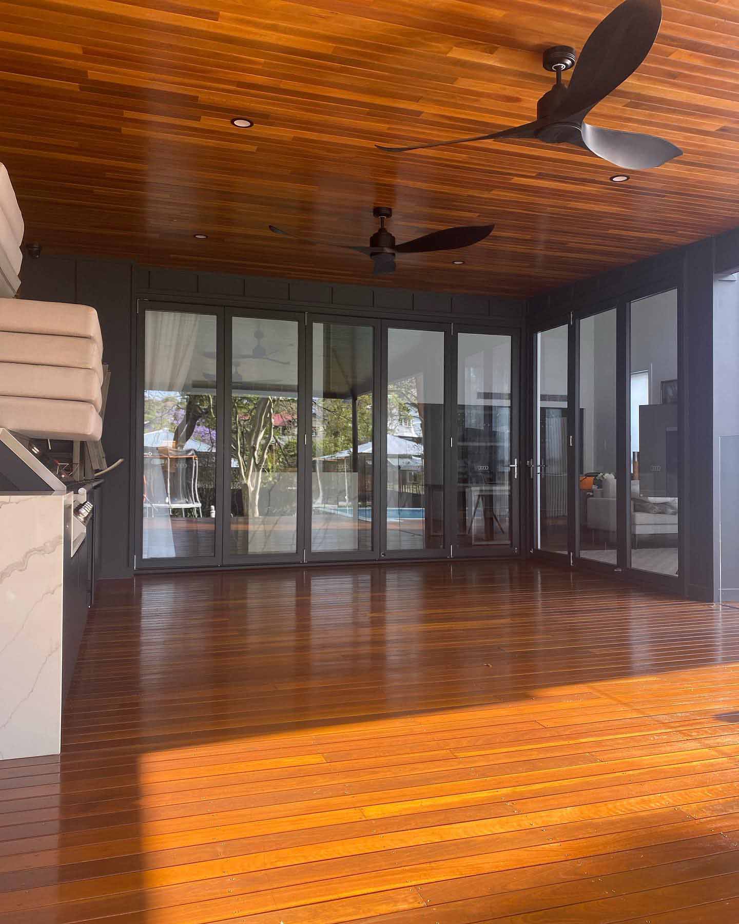 Glossy timber floor under a timber-lined ceiling with ceiling fans