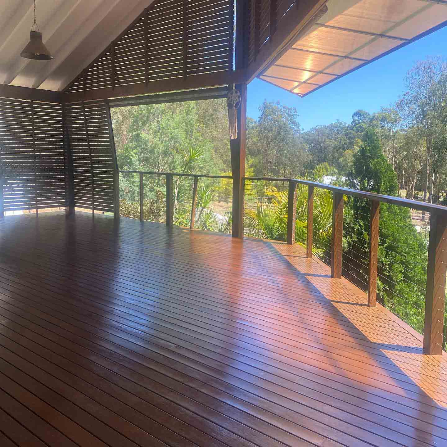 Glossy oiled timber deck with slatted screens and timber and wire balustrade