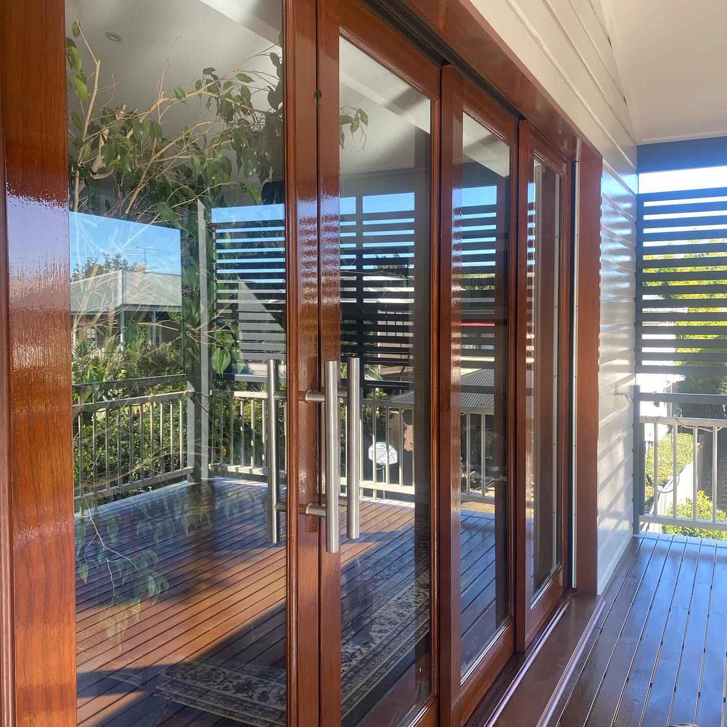 Freshly oiled timber French doors and deck seen up close