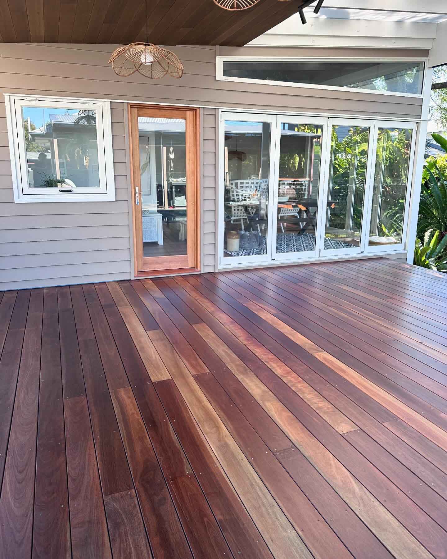 Freshly sanded timber deck with mixed board tones outside a weatherboard home
