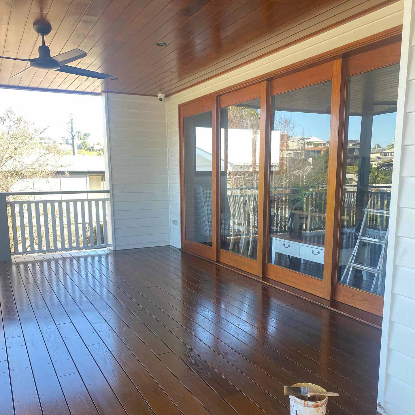 Oiled timber deck under a timber-lined ceiling beside timber-framed sliding doors