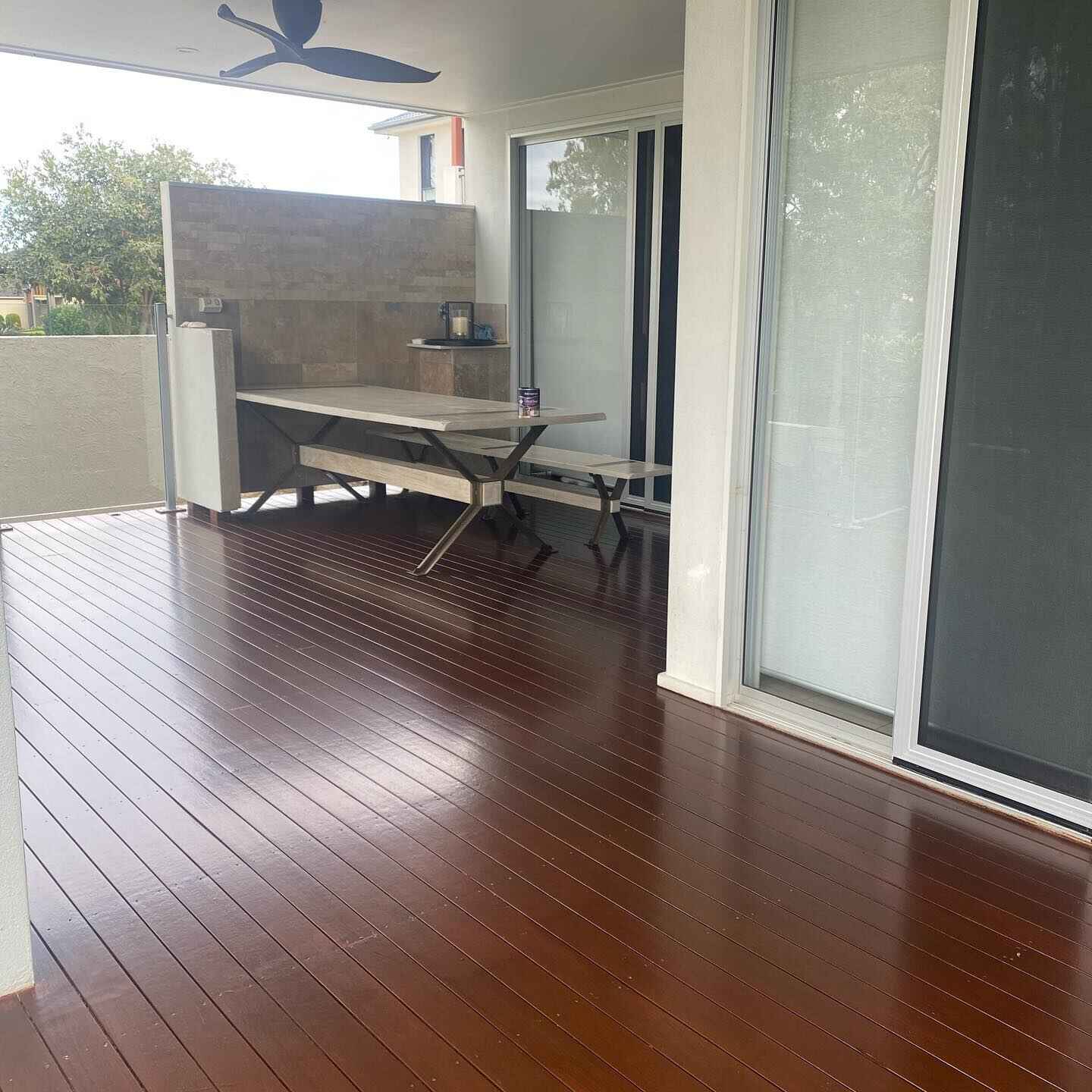 Dark oiled timber deck under a patio with an outdoor dining table