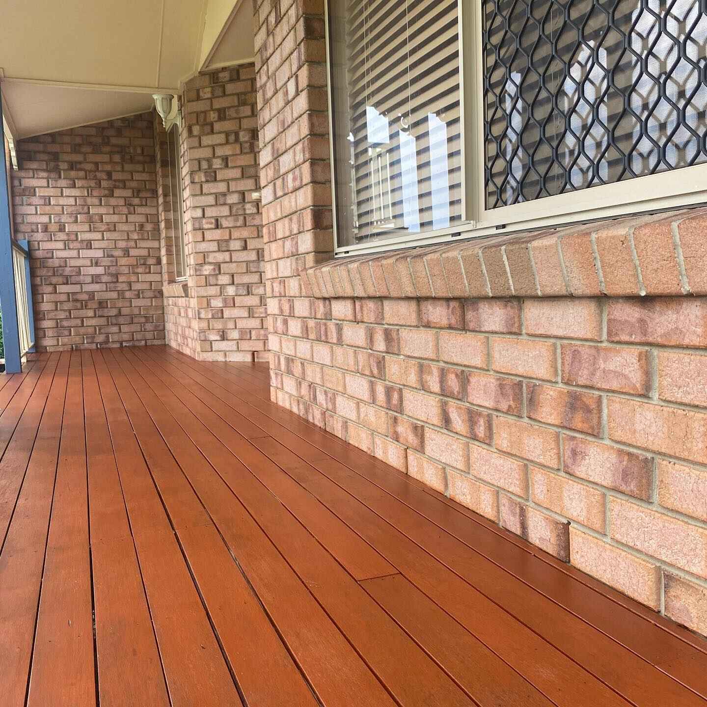 Oiled timber verandah along a brick house with security screens