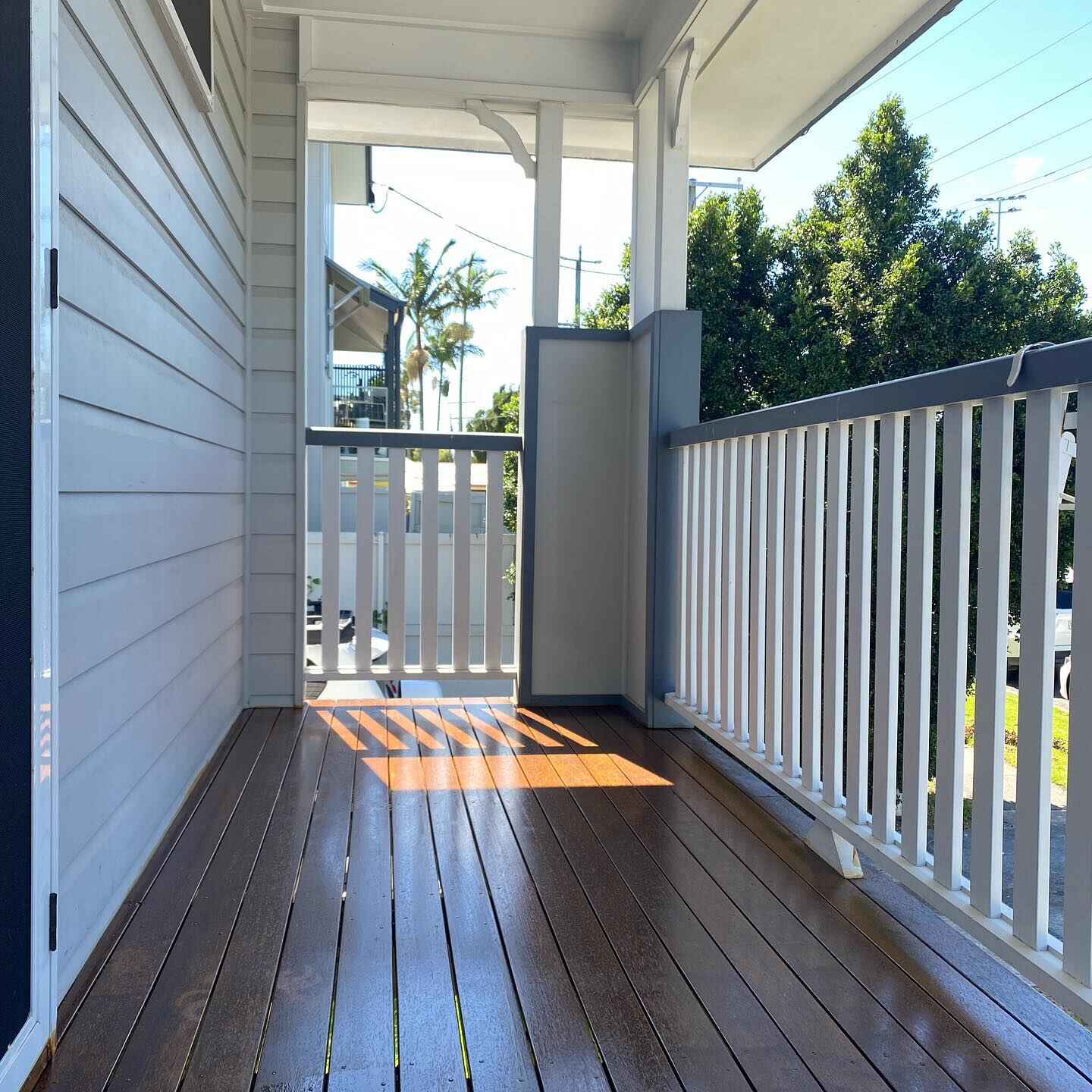 Narrow oiled timber front verandah with white balustrade