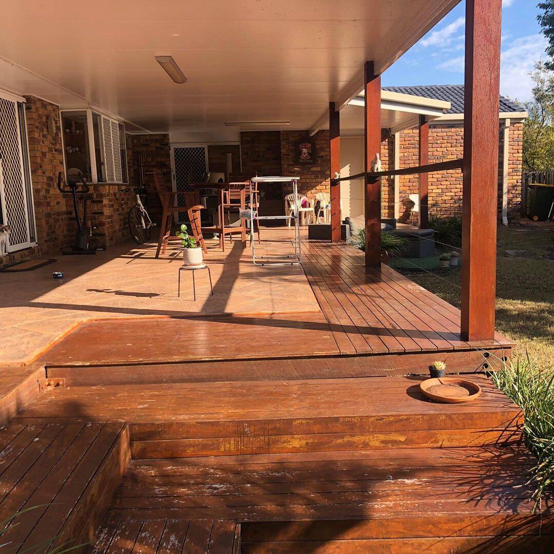 Oiled timber deck with built-in steps under a long patio roof