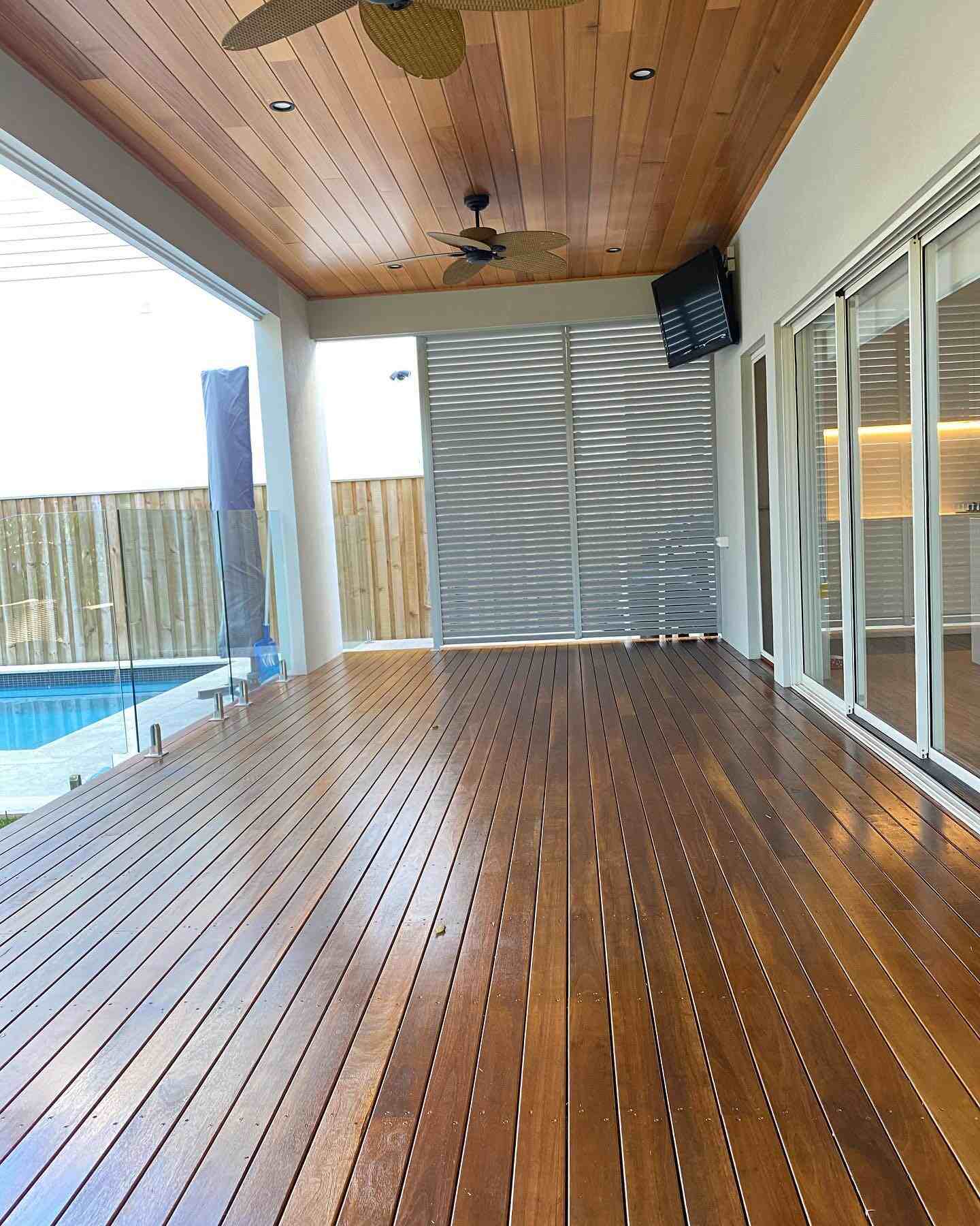 Glossy oiled timber deck under a timber-lined ceiling with ceiling fans