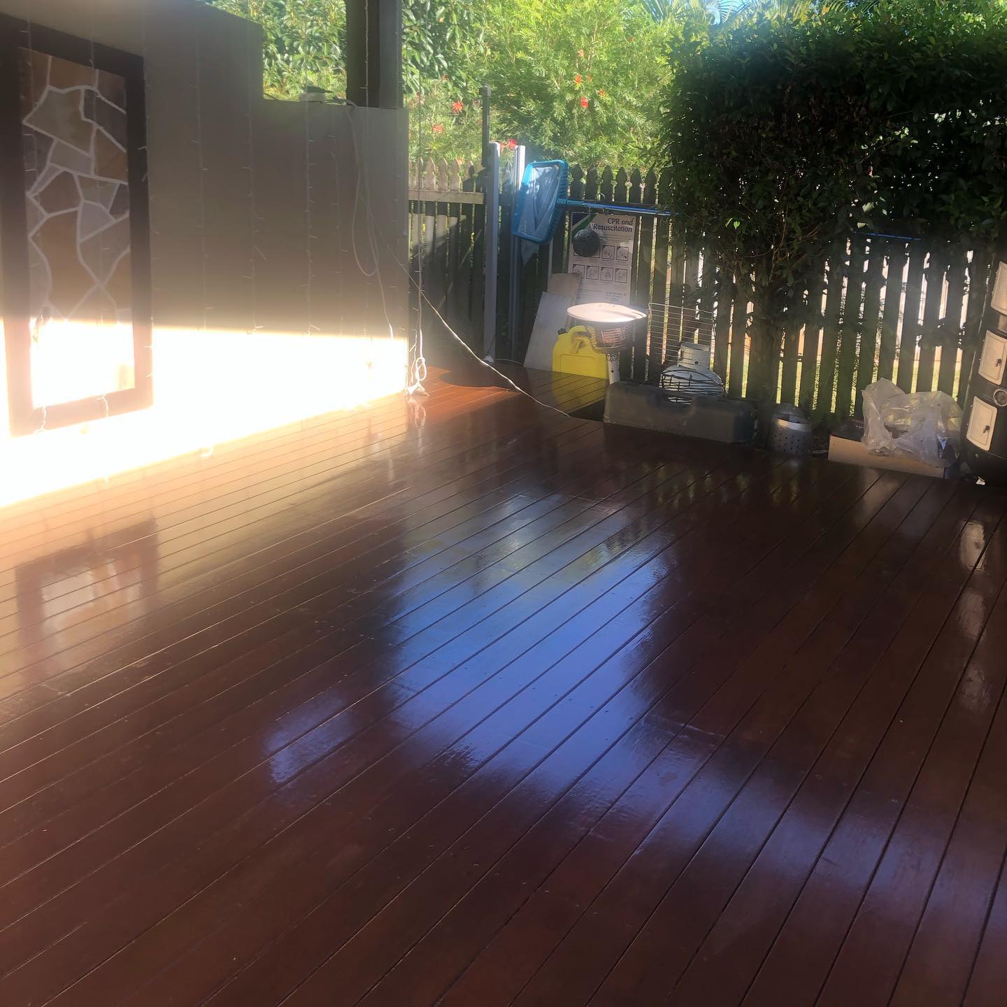 Glossy oiled timber deck in a courtyard with a timber fence