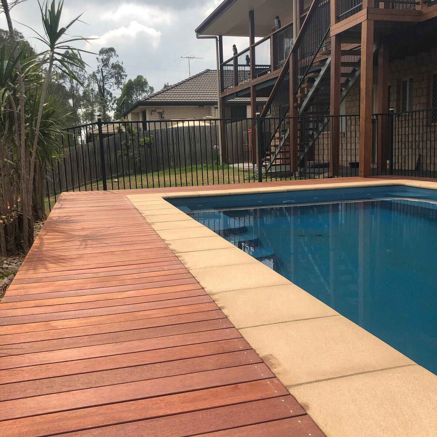 Oiled timber deck along a pool with sandstone coping