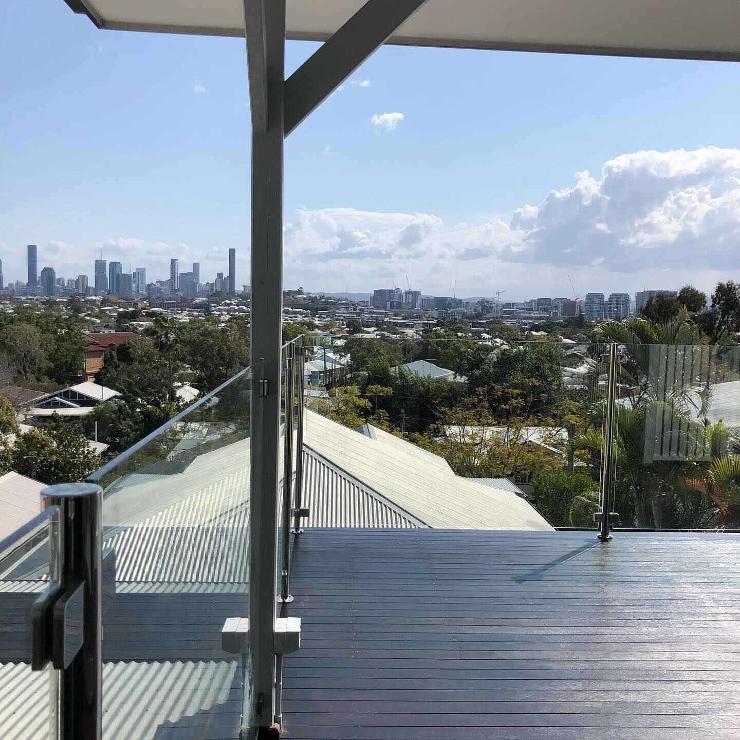 Grey-coated balcony deck with glass balustrade overlooking a city skyline