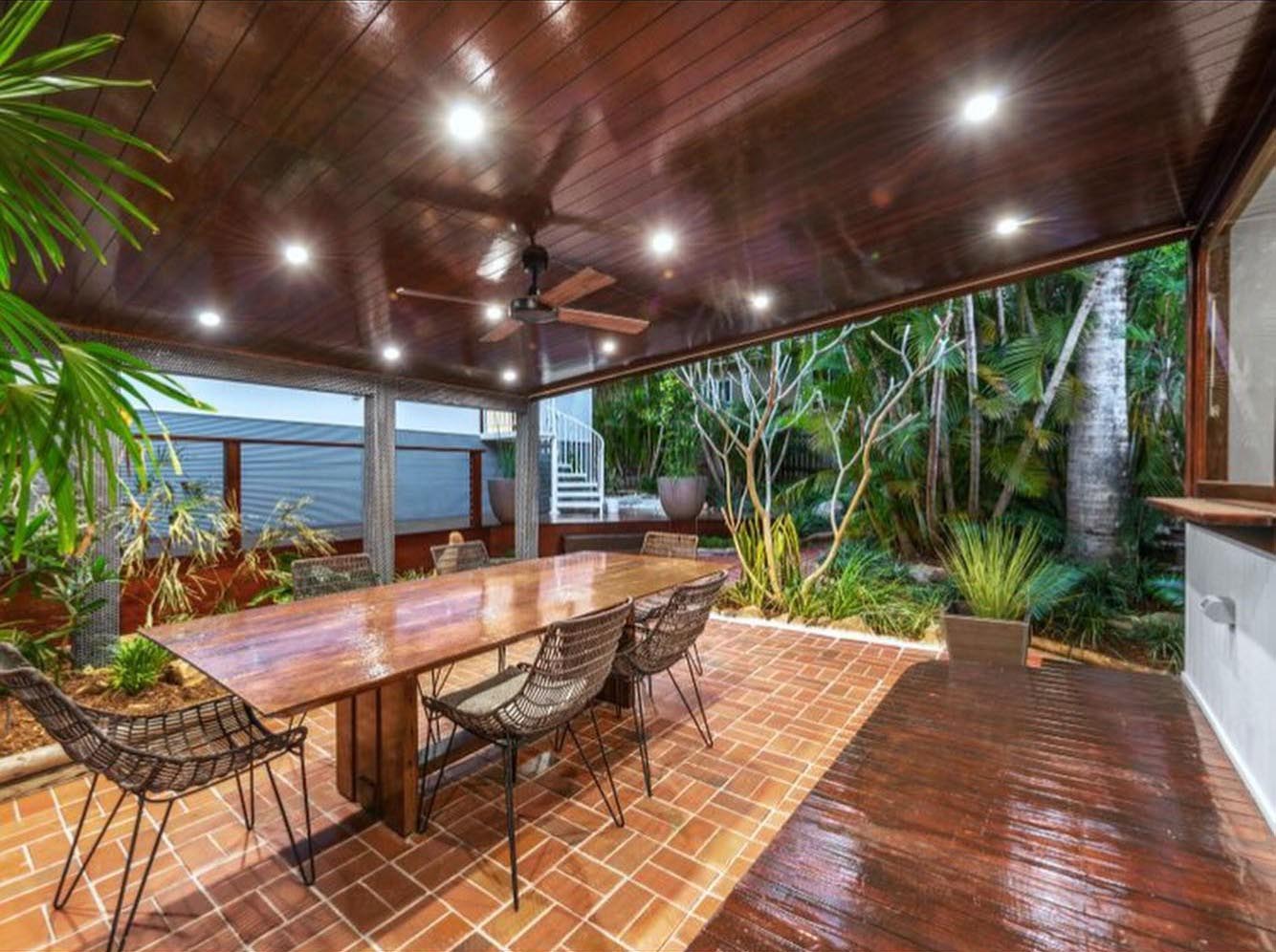 Covered outdoor dining area with a timber-lined ceiling, downlights and timber table