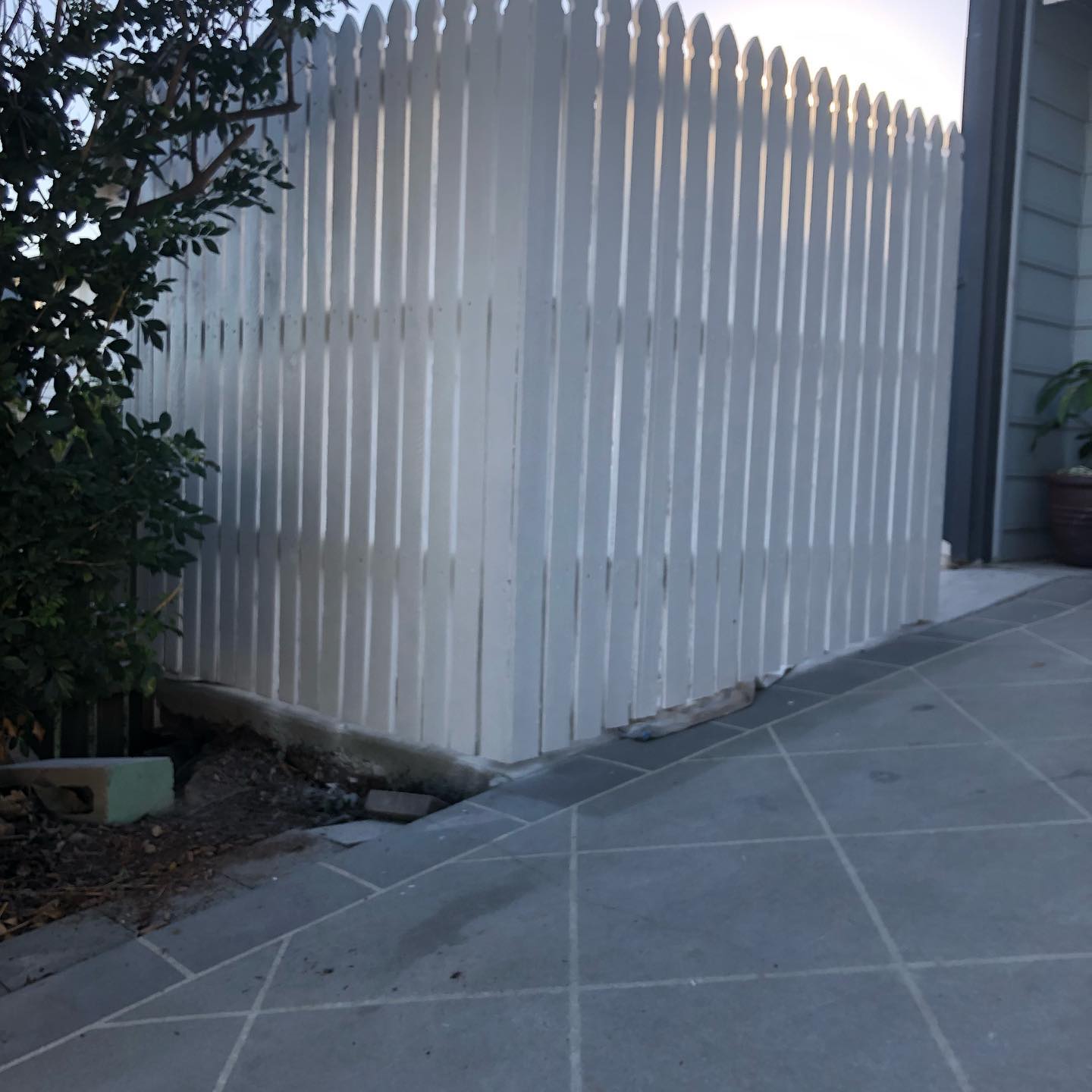 White painted picket fence beside a paved path