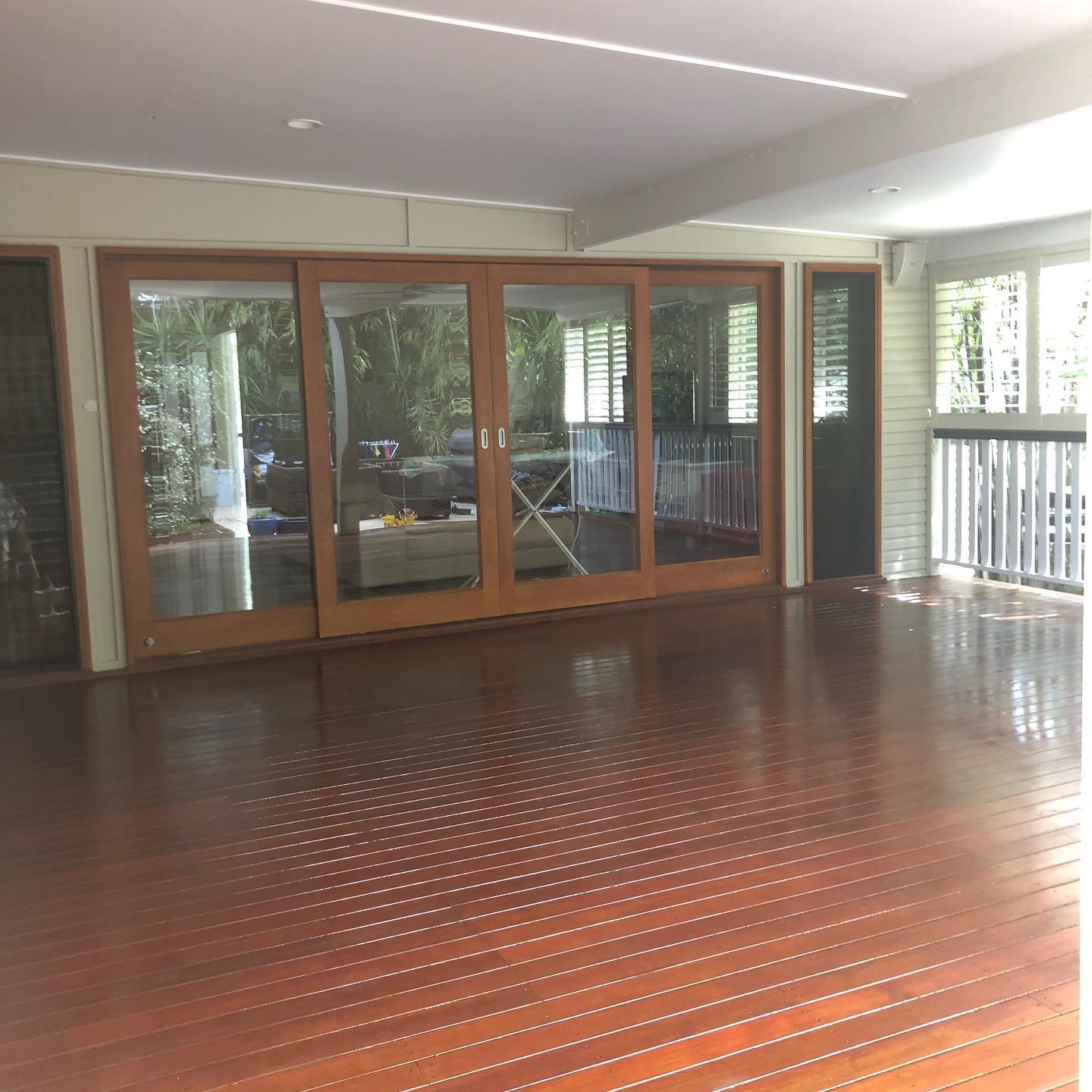 Glossy oiled timber floor in an enclosed room with timber-framed glass doors
