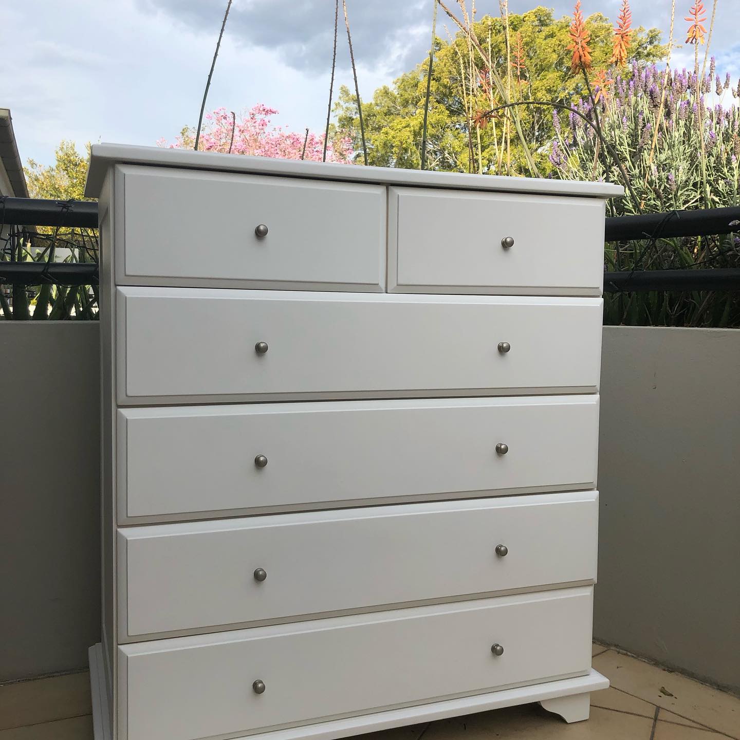 White painted chest of drawers on a balcony