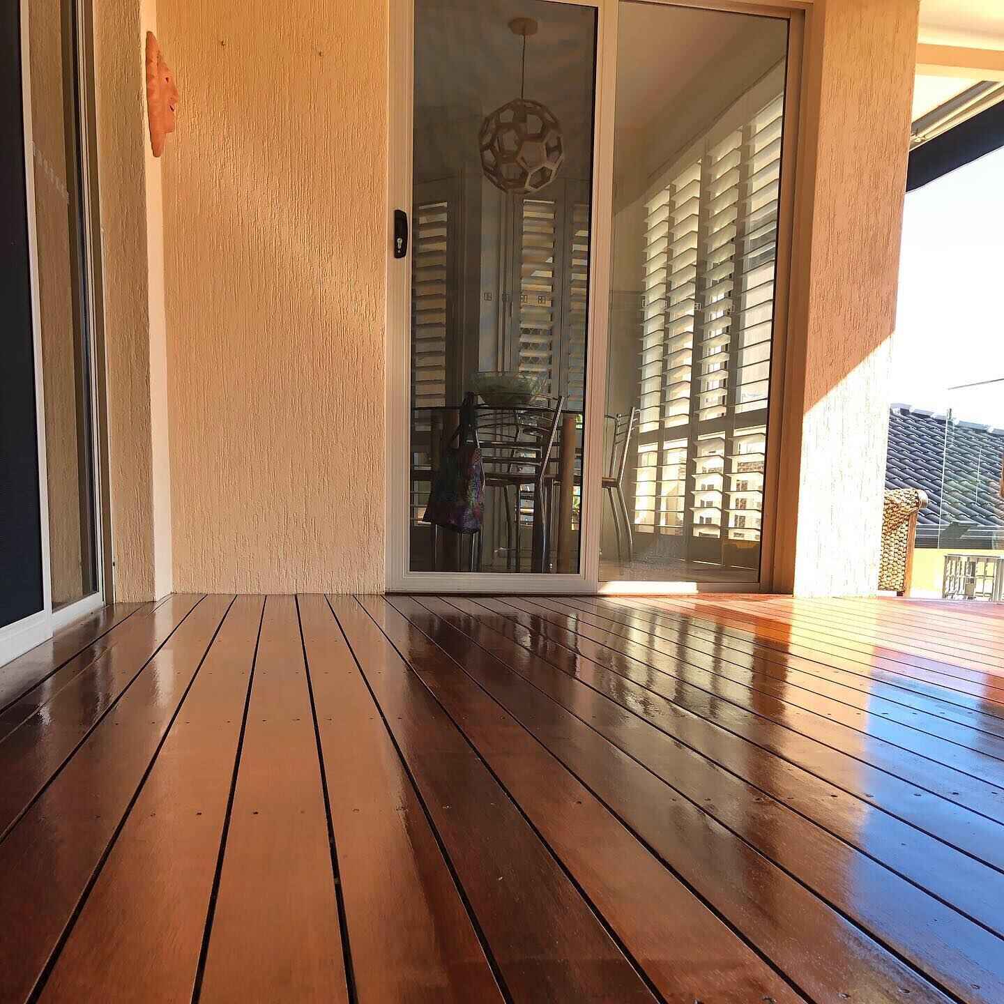 Close view of glossy oiled timber deck boards outside sliding doors