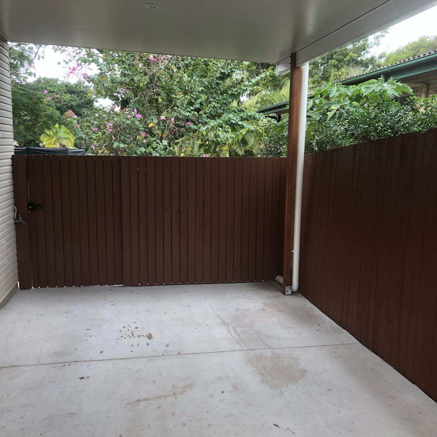 Oiled timber paling fence around a concrete patio