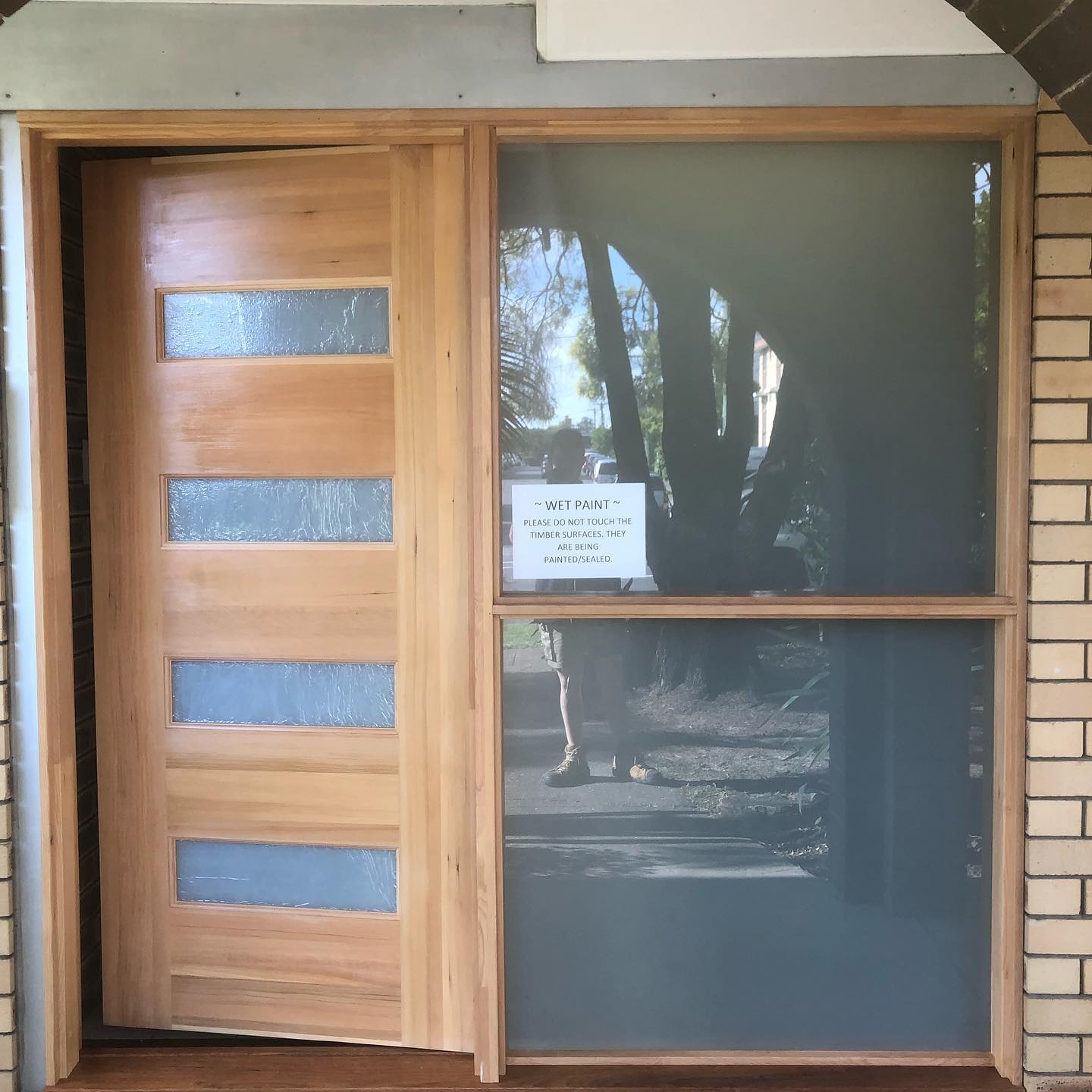 Timber front door and sidelight with a wet paint sign