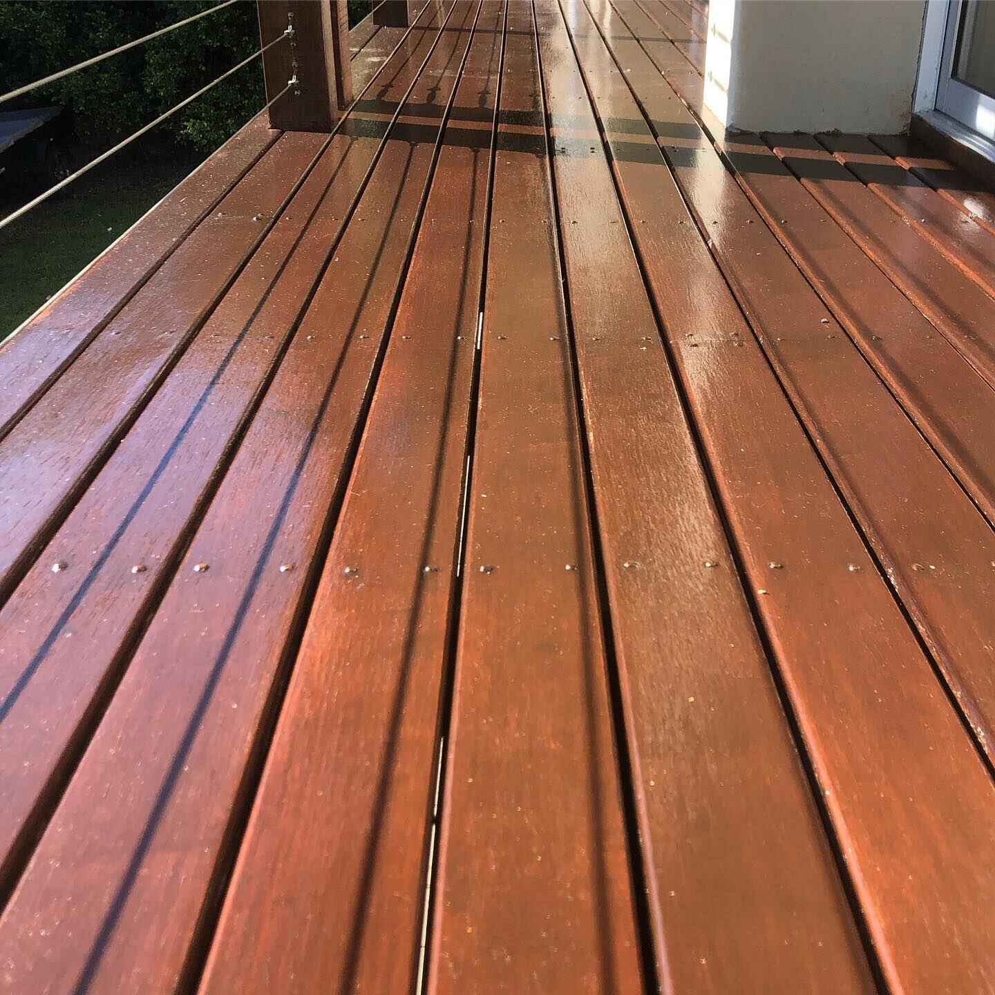 Close view of oiled timber deck boards with wire balustrade