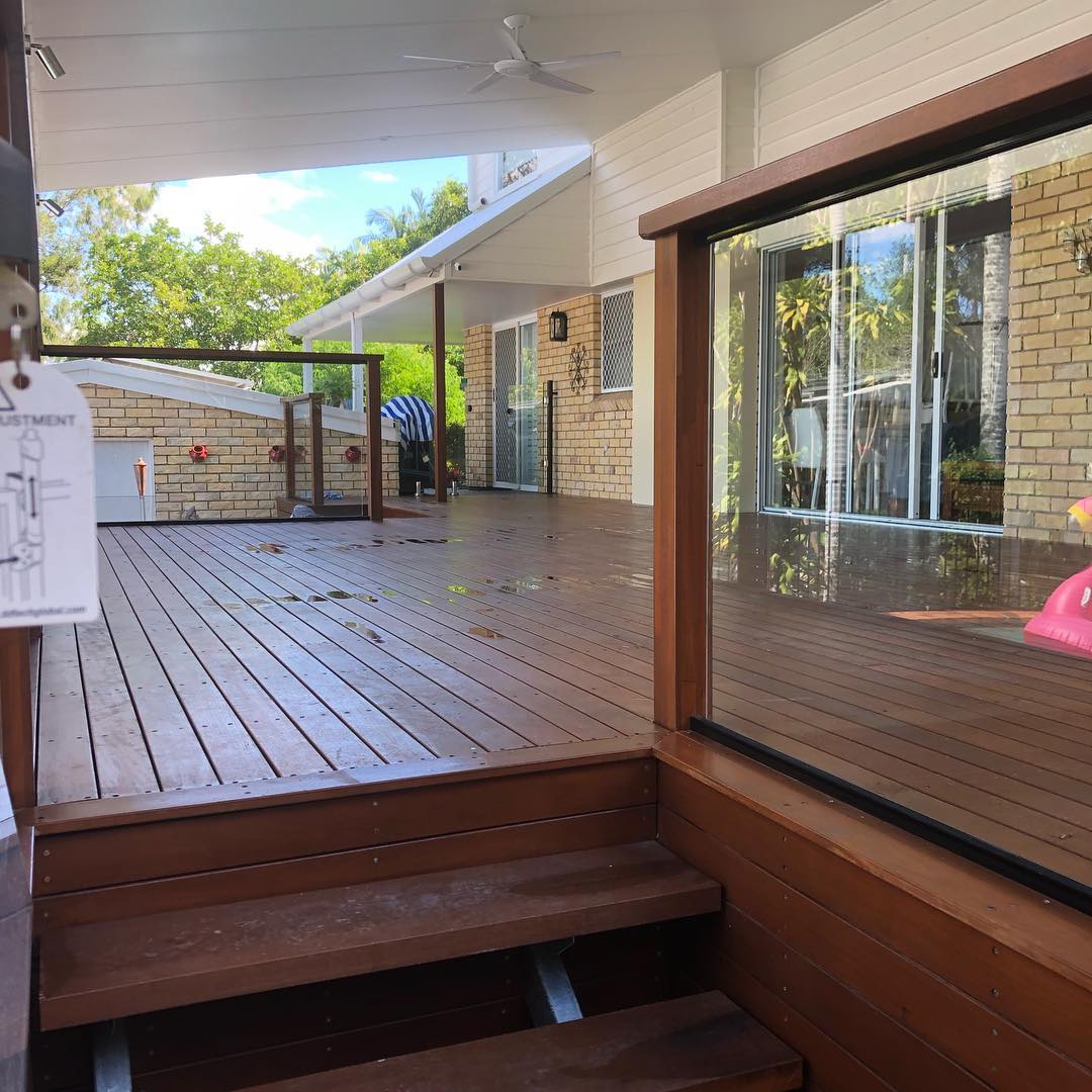 Oiled timber deck with steps up to a glass-panelled upper level