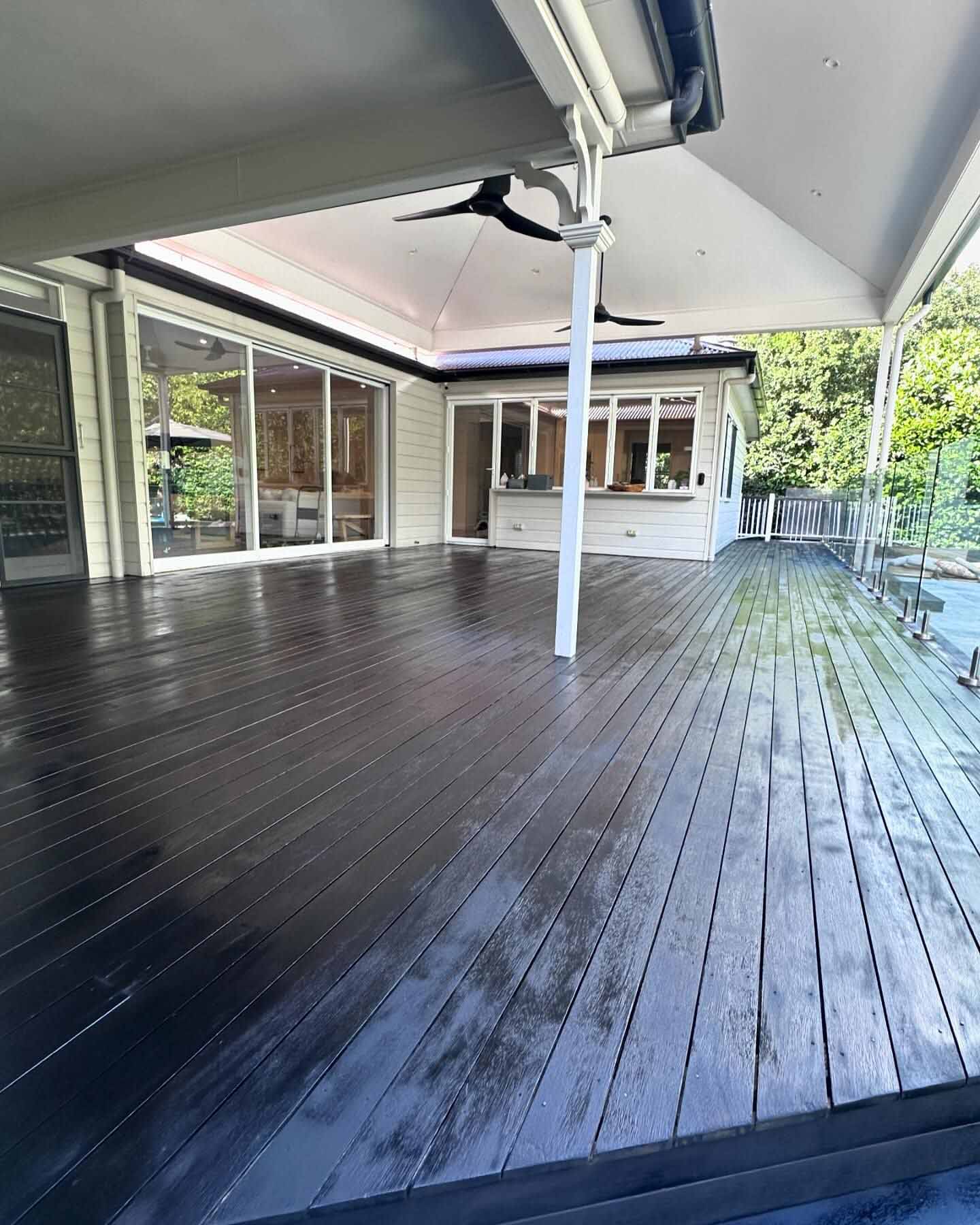 Charcoal-stained deck under a pavilion roof, seen from the corner