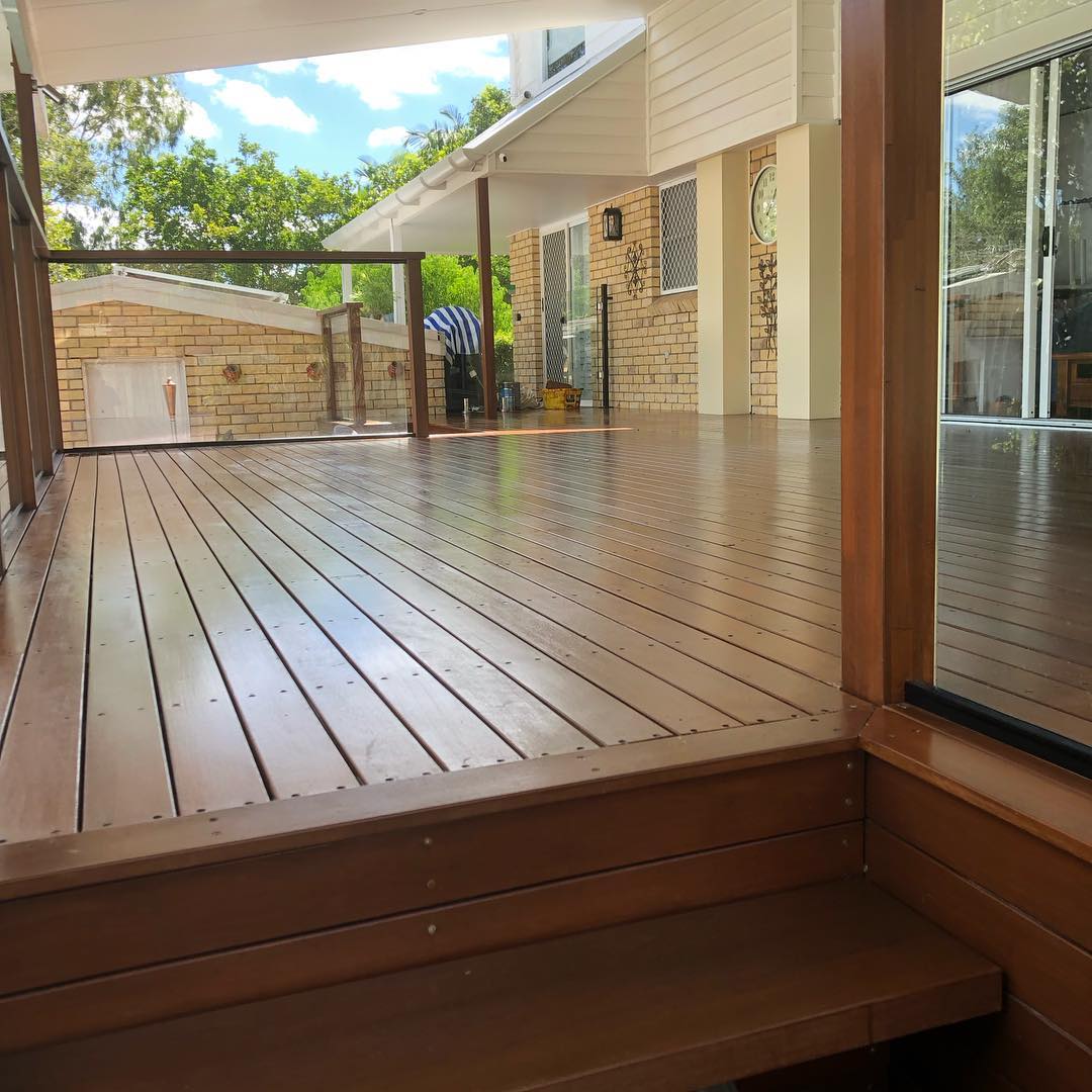 Two-level oiled timber deck with a step and glass panel, closer view
