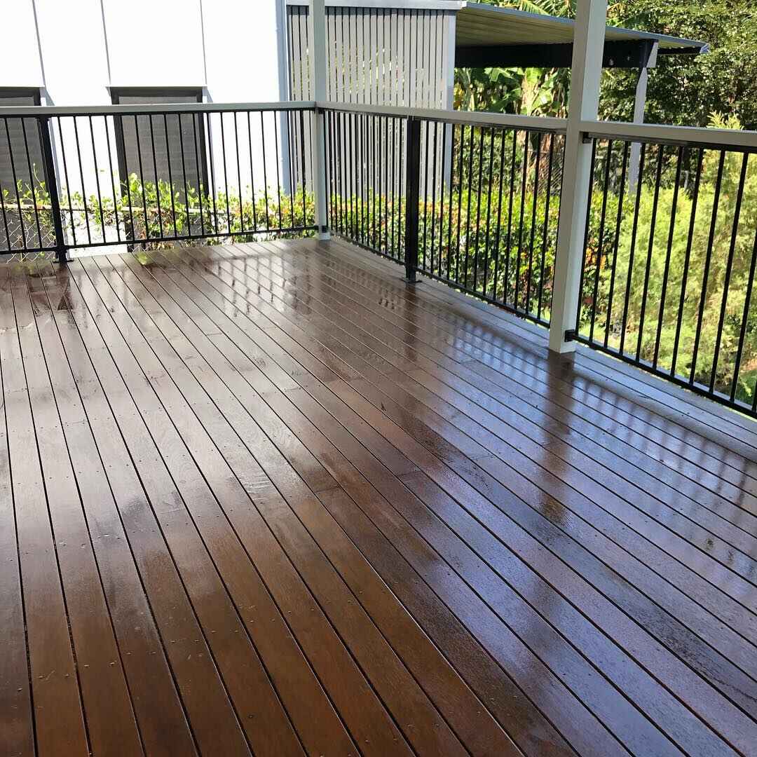 Glossy oiled timber deck with black balustrade and white posts