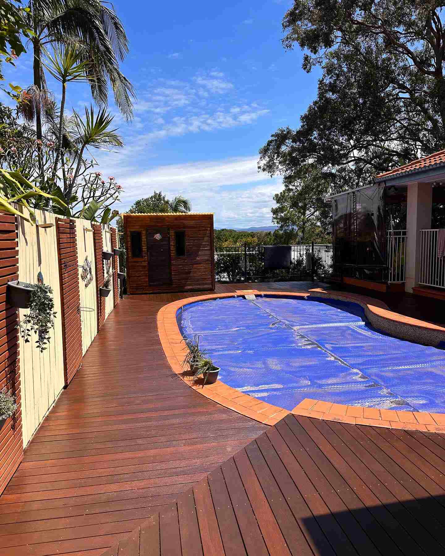 Oiled timber deck surrounding a covered kidney-shaped pool